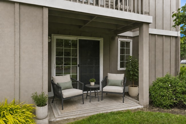 Charming apartment patio with cozy seating, lush greenery, and modern design elements perfect for relaxation.