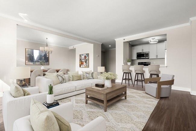 Elegant open-concept living space featuring stylish living and dining areas, and a modern open kitchen with bar seating at Parkside Place, apartments in Cambridge, MA