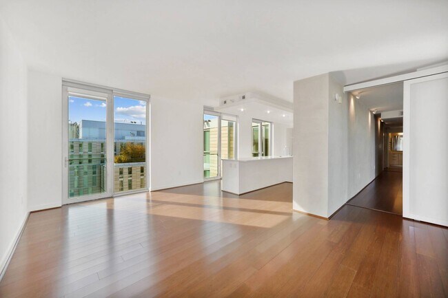 Disfrute de la luz natural y la elegancia moderna en este apartamento de concepto abierto, que cuenta con lujosos pisos de madera y ventanas de piso a techo.