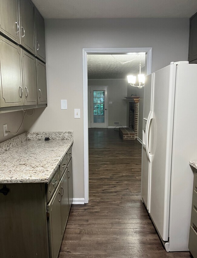Kitchen - view past fridge & countertops, look past to see dining & living rooms and door to lanai - 440 Williamsburg Way