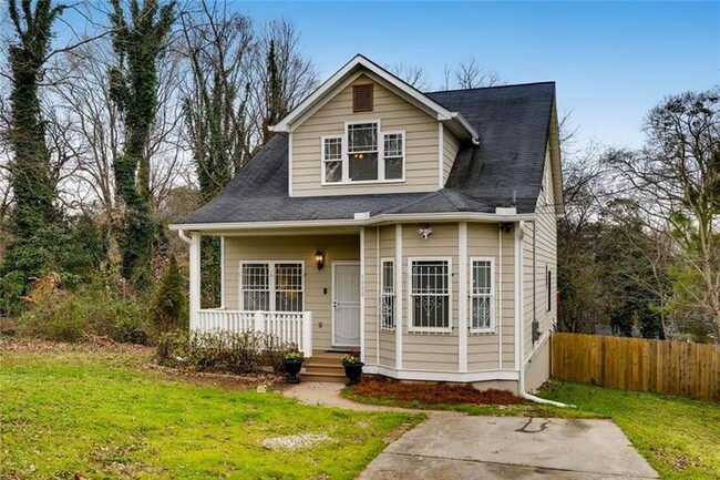 Front yard with a porch and driveway for parking. - 1999 Meador Ave SE Casa