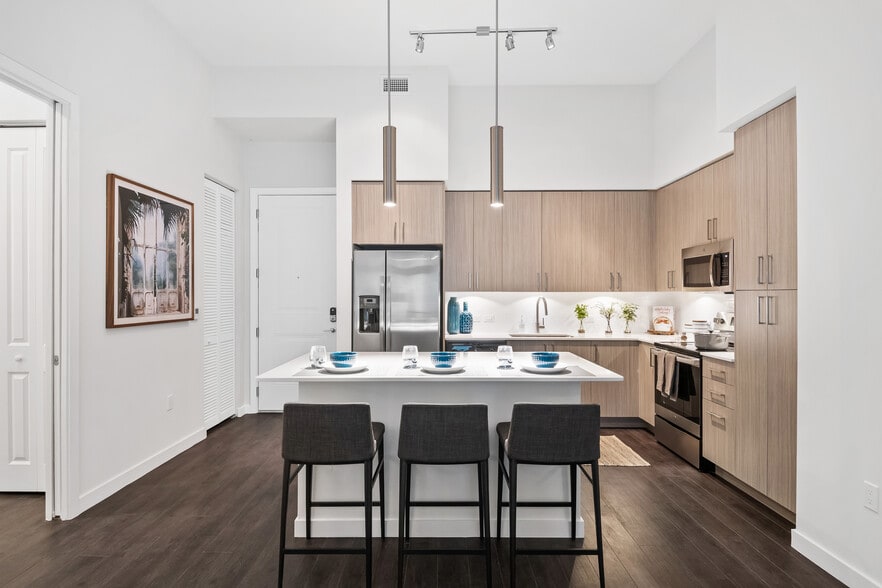 Kitchen with oak cabinetry, undercabinet lighting, white quartz countertops, and hard-surface vinyl plank flooring