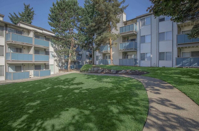Front entrance to Foster Creek Apartments, featuring well-kept lawns, trees, and inviting residential architecture.