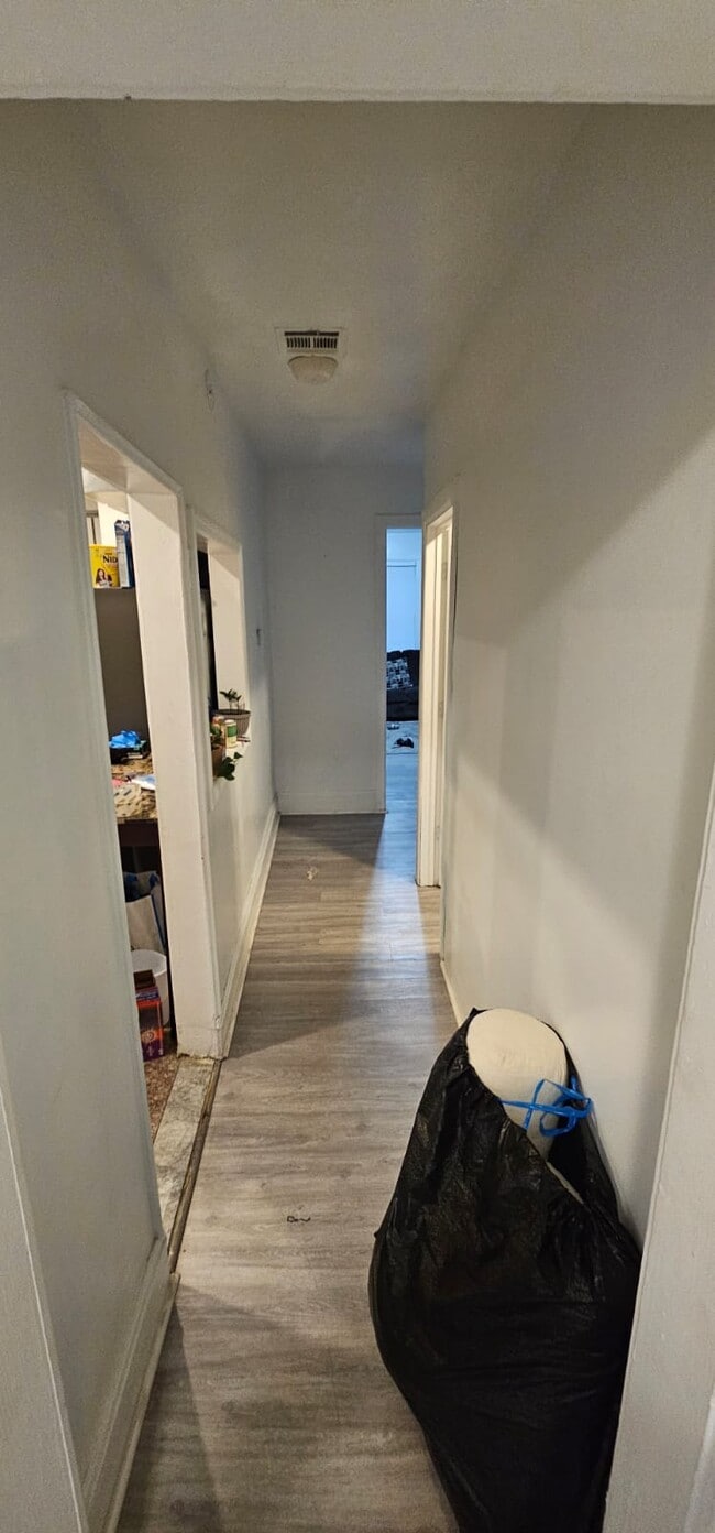 El pasillo conecta con la primera habitación, la cocina, el baño y los dos dormitorios restantes. - 157 N 15th St Unidad 2
