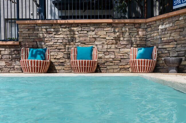 Asientos junto a la piscina en el spa para residentes con cojines coloridos