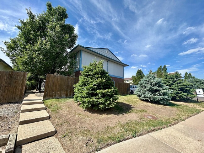 Encantadora casa suburbana con exuberante vegetación y un cielo azul despejado, que ofrece una vida tranquila en un vecindario pintoresco. - 10756 West 12th Lane