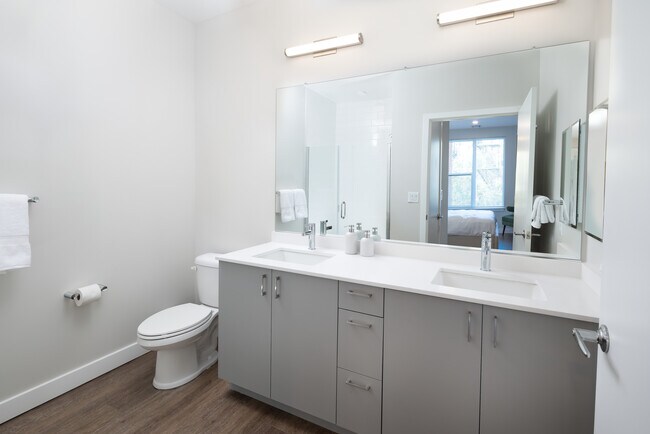Modern baths with light grey cabinetry, white quartz countertop, and hard surface flooring