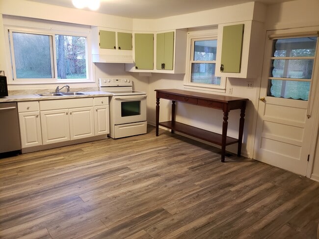 Large eat-in kitchen has new vinyl flooring and door to the covered patio.