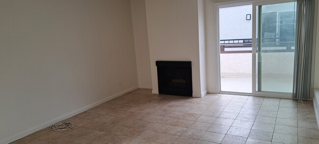 LIVING ROOM WITH FIREPLACE AND SLIDER TO BALCONY, TRAVERTINE STYLE PORCELAIN TILES - 314 20th St Unit D
