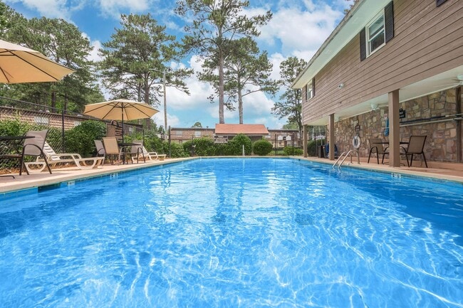 Relax in the inviting pool at Guest House, surrounded by lush landscapes and sunshine. Enjoy the perfect blend of comfort and community. Schedule a tour today and see why this is the ideal place to call home!