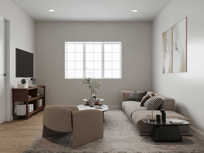 Sala de estar moderna con luz natural, acabados neutros y cómodos asientos en los apartamentos Cresta Ranch en Santa Fe, Nuevo México. Comunidad de apartamentos asequibles para personas de bajos ingresos.