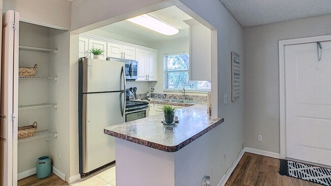 Featuring modern cabinetry, ample countertop space, stainless steel appliances, and a breakfast bar, this thoughtfully designed space makes cooking, dining, and entertaining effortless.