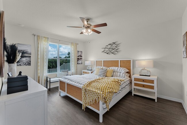 Bright and spacious primary bedroom with large window and modern ceiling fan.