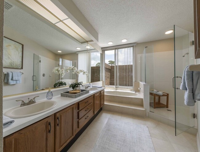 Primary bathroom with double-vanity, walk-in shower, and whirlpool tub