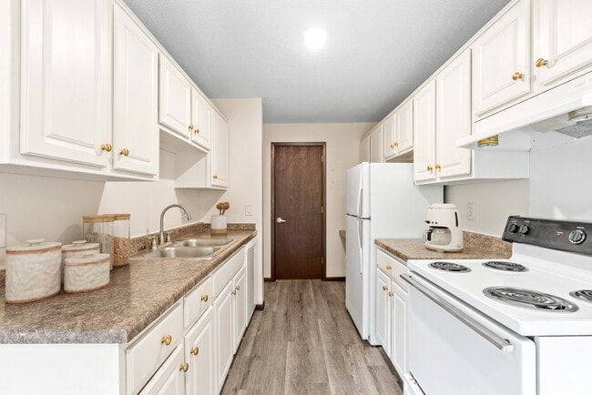 Bienvenidos a Como Park Apartments, donde la vida moderna se une a la comodidad. Esta espaciosa cocina cuenta con elegantes gabinetes y electrodomésticos modernos, perfectos para los amantes de la cocina. ¡Venga a descubrir cómo puede mejorar su estilo de vida hoy mismo! ¡Programe una visita ahora! - Como Park Apartments