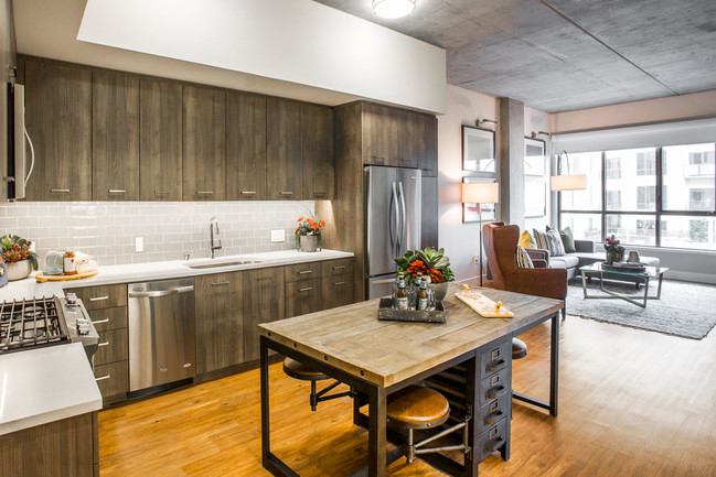 Kitchen with 5-burner range, island and full height backsplash - The Marston by Windsor Apartments