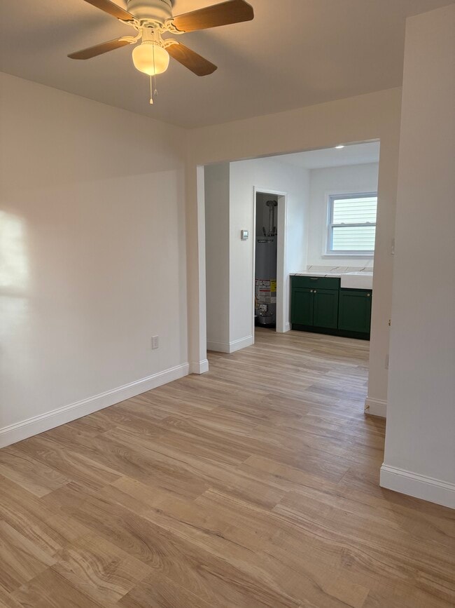 Living room looking into kitchen. Utility closet houses washer/dryer with room for storage. - 410 E Point Pleasant Ave Unit Rear