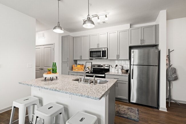 Nova-Knoxville-Formerly-Aspen-Heights-Knoxville-Off-Campus-Apartments-Near-The-University-of-Tennessee-Knoxville-Full-Kitchen-Stainless-Steel-Appliances-Tile-Backsplash-Granite-Countertops-Kitchen-Island-with-Barstool-Seating - Nova Knoxville
