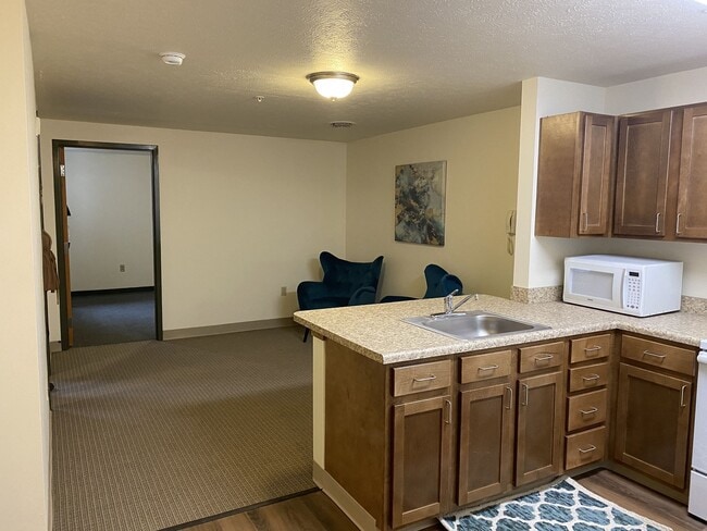 Cocina con gabinetes de madera - Carson Square Apartments