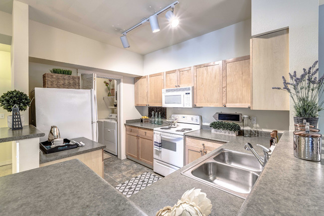 Open kitchens with energy efficient appliances, including dishwasher and mounted microwave - The Lodge at Redmond Ridge Apartments