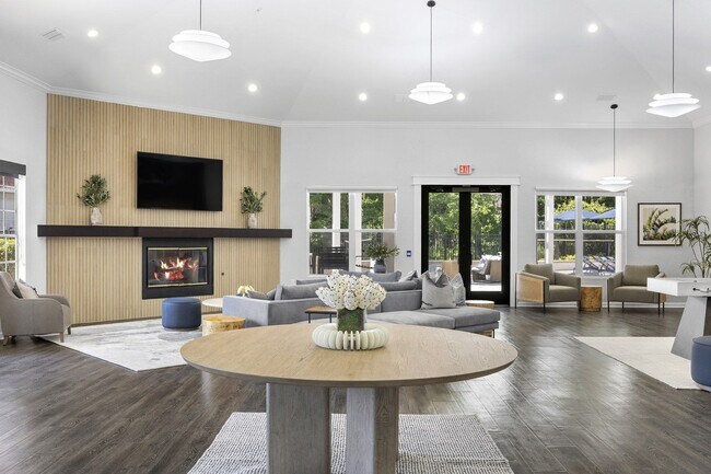 Resident clubroom with fireplace and sectional seating, made for settling in with friends - Windsor Highwoods Preserve