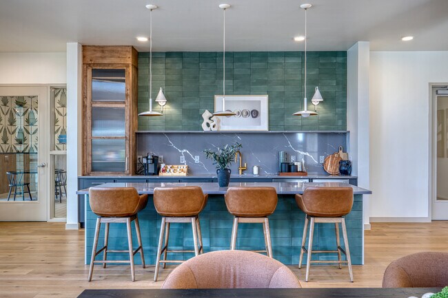 Modern community kitchen with a spacious island and ample seating at Residence at Pearsall Park
