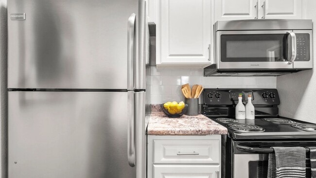 Our newly remodeled kitchens impress with timeless white cabinetry, elegant granite-style countertops, and a prominent white subway tile backsplash. - Level 550
