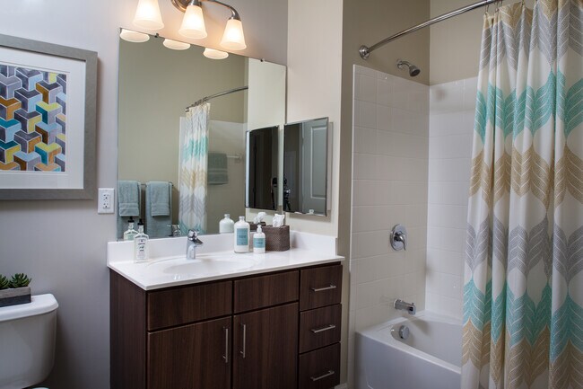 Baño clásico de chocolate con gabinetes de nogal, encimeras de laminado blanco, y pisos de superficie dura - Avalon Framingham
