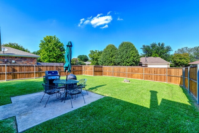Large fenced backyard (great for dogs). Patio with table and chairs and Weber gas grill