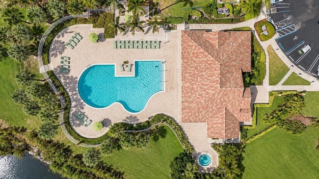 Dive into resort-style living at Whaler's Cove. This stunning aerial view showcases a sparkling pool surrounded by lush landscaping, perfect for relaxation and entertainment. Ready to make it your new home? Inquire today!