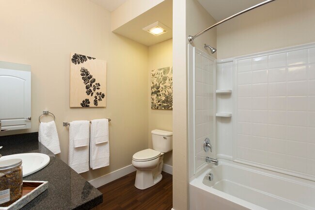 Classic Package III bath with black speckled granite countertop, oak cabinetry, and hard surface flooring