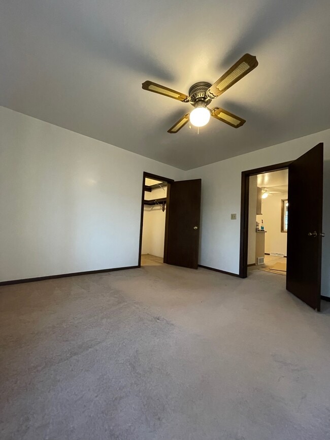 Bedroom with ceiling fan and walk-in closet - N5385 Co Rd V Unit #1