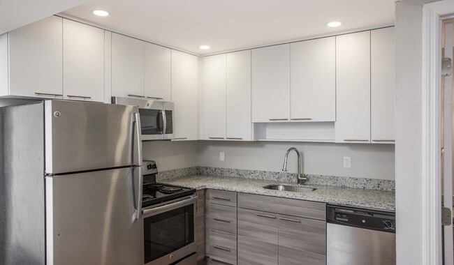 Modern kitchen features stainless steel appliances, granite countertops and designer cabinets
