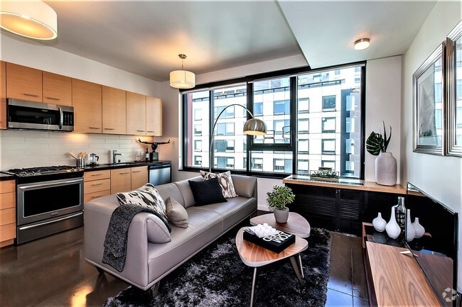 Modern living room with a view in a San Francisco apartment with the kitchen in the background. - Olume Rental