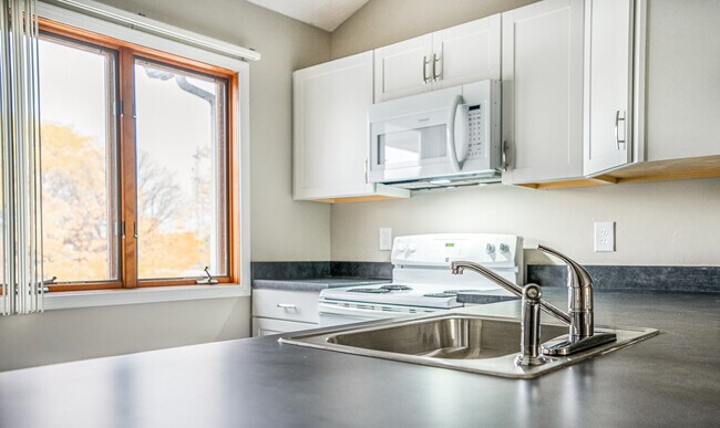 Typical Apartment Kitchen with Faux Marble Counters & White Cabinets