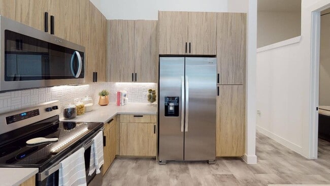 Gourmet kitchens with stylish mosaic tile, quartz countertops and plentiful storage. Some homes feature double-door refrigerators with water dispensers and dedicated pantry space too! - Modera Washington