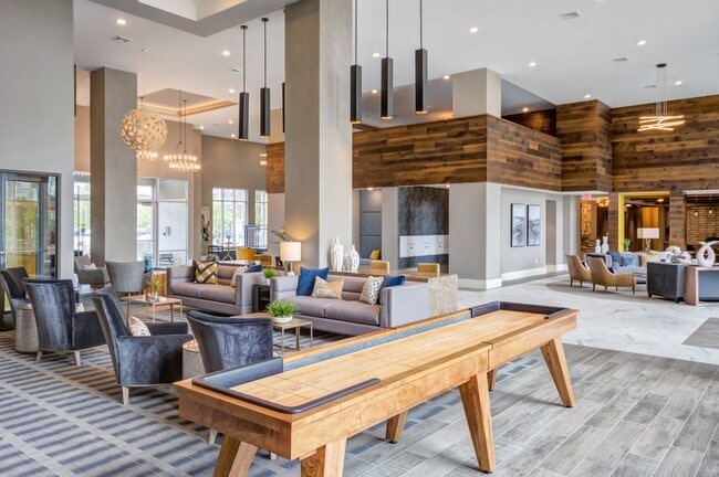 Amplia casa club con elegantes asientos, juegos y un diseño sofisticado, perfecta para relajarse o socializar. - The Heights at Goose Creek Village