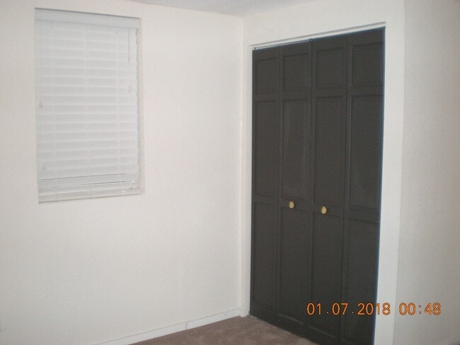 Second bedroom lower level, new carpet and paint and large east facing window for sun and safety exit. - 1160 Clinton St Townhome