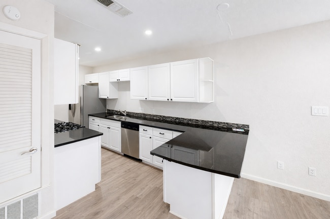 Light-filled, open kitchen with granite countertops and stainless steel appliances. - 5917 Little Creek Trl