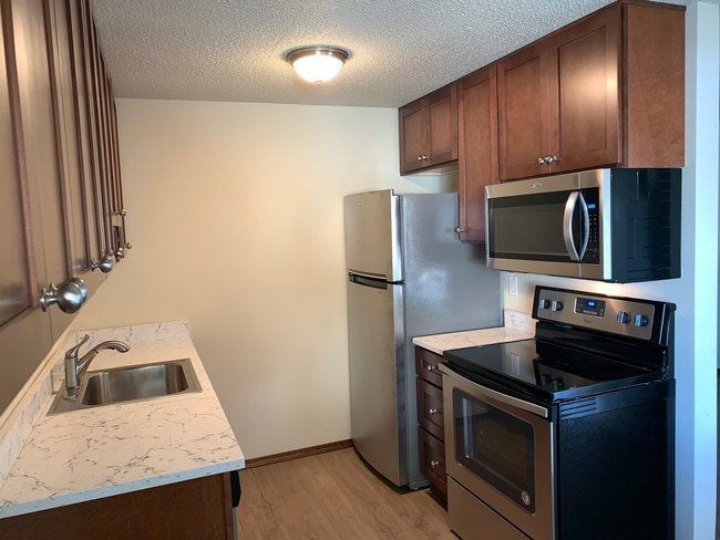 Encimeras de cuarzo y electrodomésticos de acero inoxidable. - Pearl Manor Apartments - 55+ Senior Living