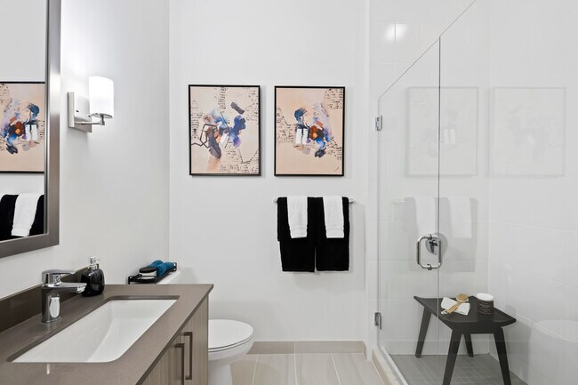 Primary bath with grey quartz countertops and hard-surface vinyl plank flooring