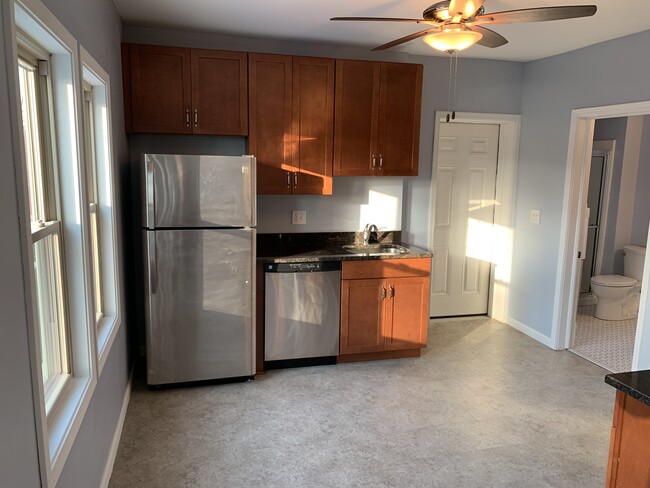 Kitchen - Appliances, ceiling fan, and apartment entrance - 3817 Lorain Avenue Apartments Unit Up