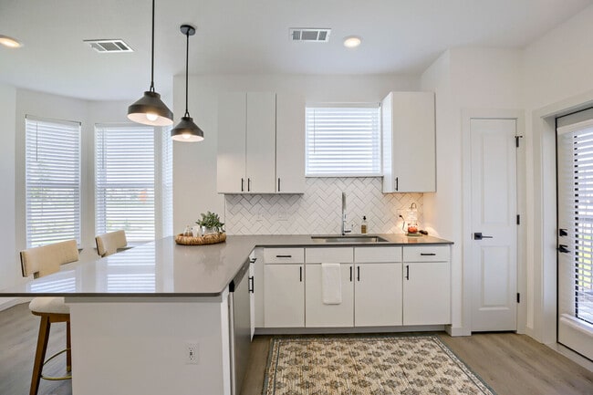 La península envolvente con lavavajillas y fregadero bajo encimera ofrece espacio para preparar alimentos, almacenamiento y vistas, todo a la vez. Garrett Harvest Junction West, Longmont, CO.