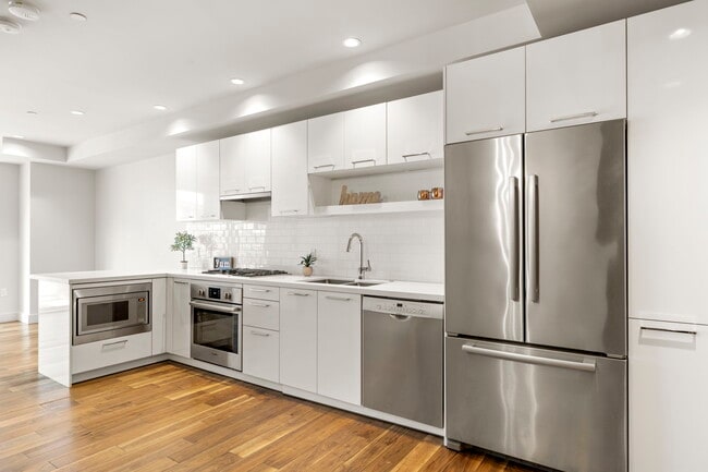 White cabinetry, quartz counters, and subway tile backplash - 4422 N 75th St Unit 2002