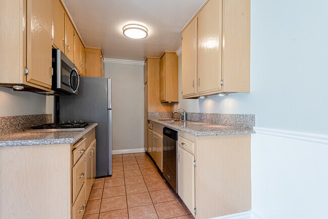 Kitchen with fridge, cooktop, microwave, dishwasher, and wall oven