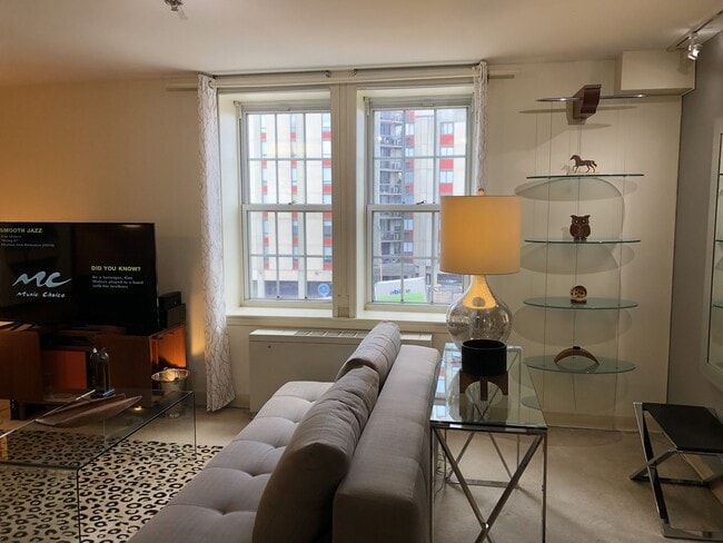 Bright apartment living room with large windows, natural light, and open-concept design