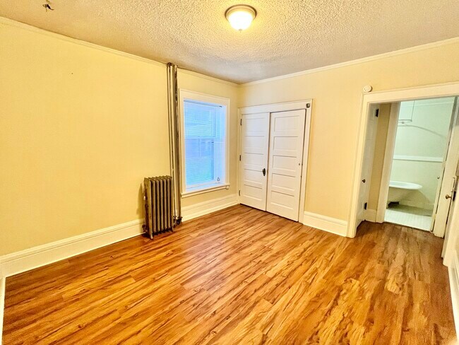Adéntrate en tu nuevo y acogedor dormitorio, que cuenta con elegantes suelos de madera noble y amplio espacio de almacenamiento. - Cross Apartments