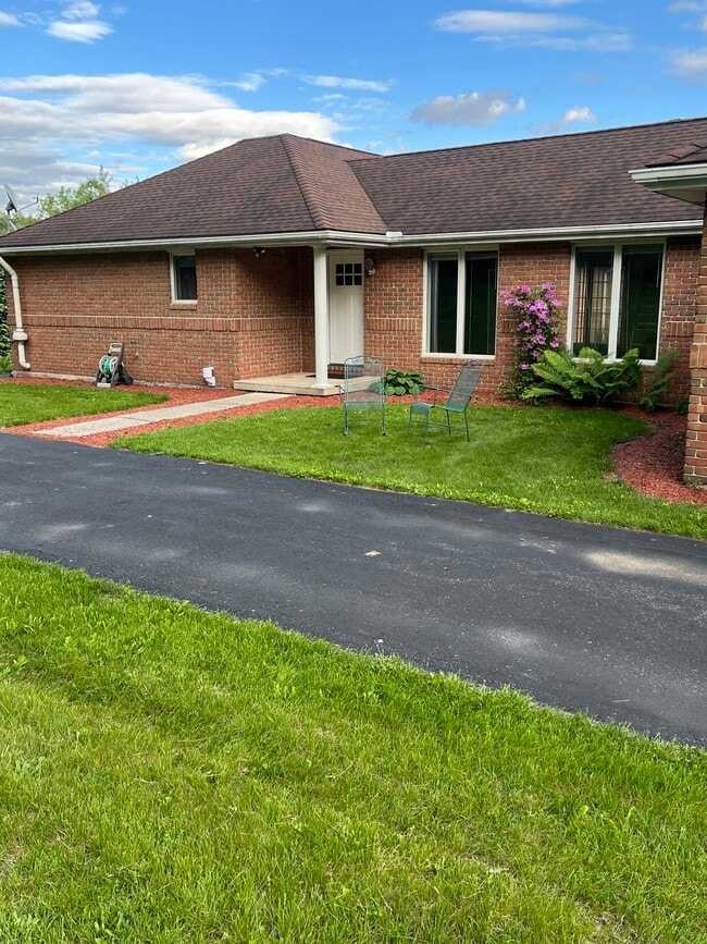 Entrance showing porch, yard and parking area - 777 S Mink Rd Apartment