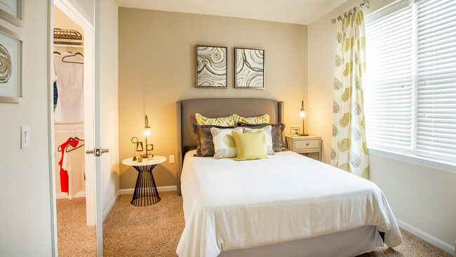 Queen sized bedroom featuring plush wall to wall carpeting