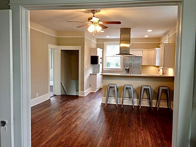 Living room and kitchen viewed from dining room. Also shown 3rd BR on far left and back stairwell - 1217 Foucher St Apartments Unit 1217